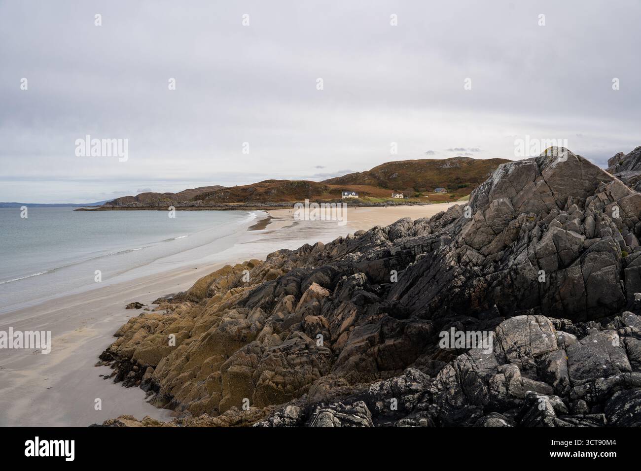 Zerklüftete felsige Küste mit Sandstrand und abgelegenen Cottages in Scottish Highlands Stockfoto