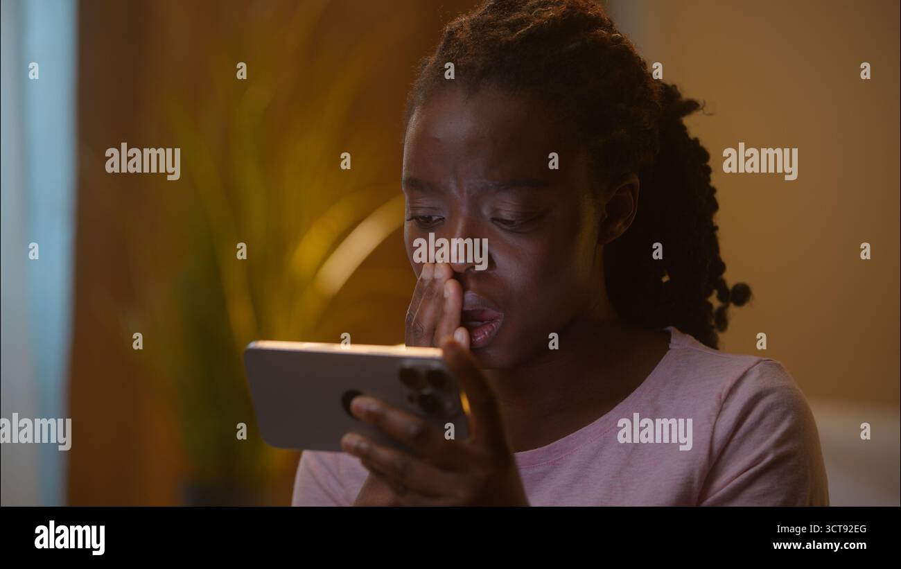 Schockiert verängstigt aufgebracht afroamerikanische ethnische Geschäftsfrau weibliches Mädchen weibliche Nutzerin Spieler hält Handy spielen Online-Spiel verlieren Wette scheitern Stockfoto