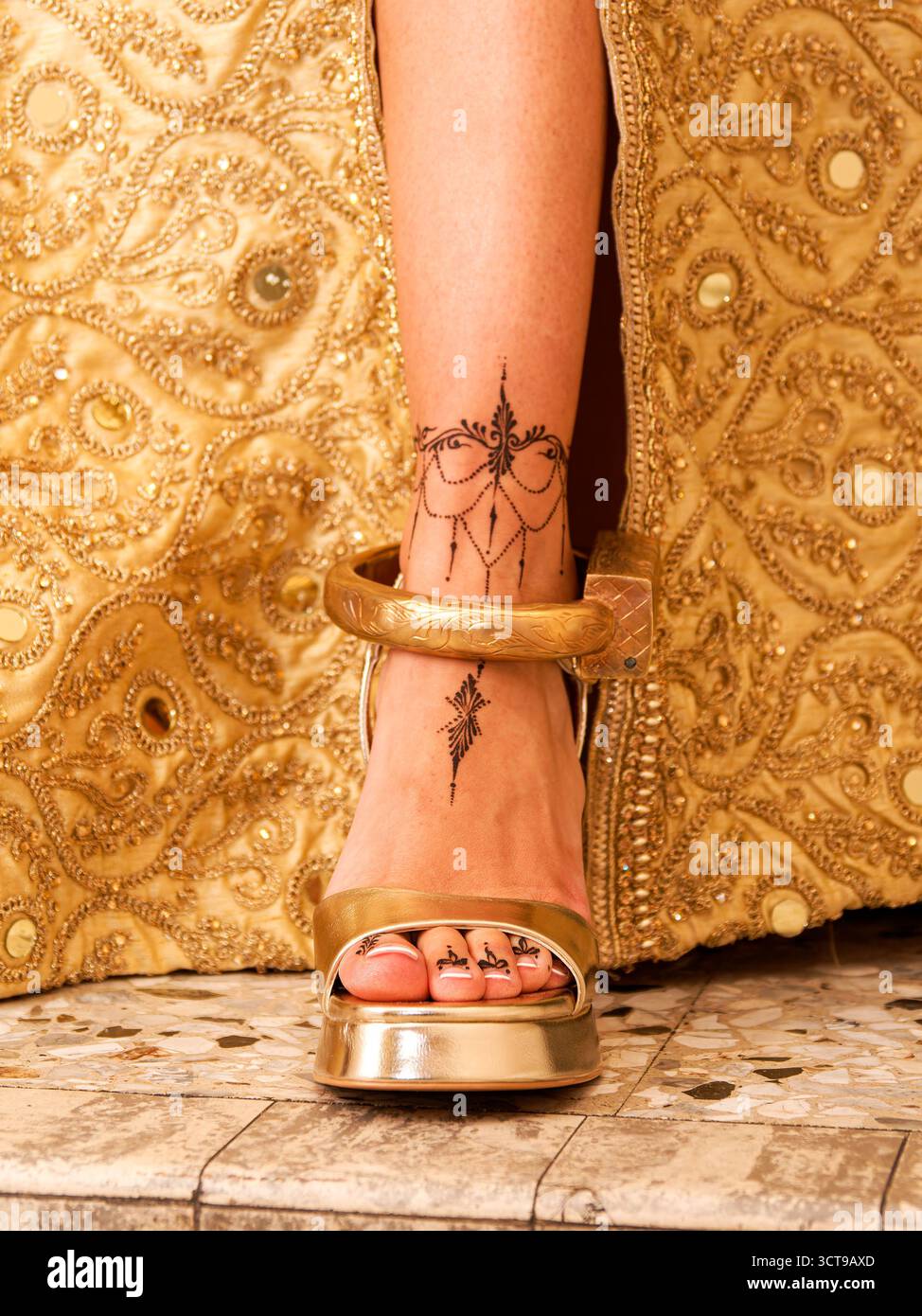 Goldene Sandalen und Henna-Details der Braut, die während der kurdisch-tunesischen Hochzeitszeremonie erfasst wurden. Stockfoto