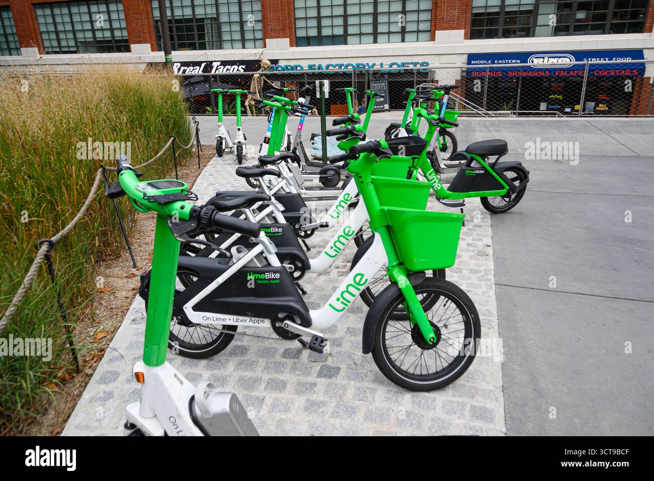 Eine Gruppe von Lime-Elektrofahrrädern kann auf dem Bürgersteig in Atlanta, Georgia, USA, gemietet werden. Stockfoto