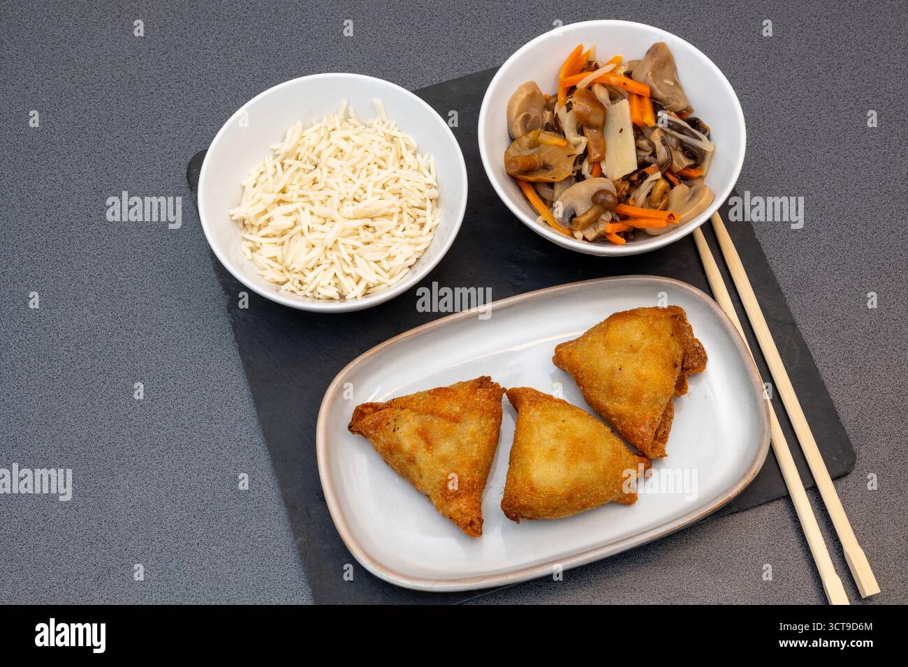 Golden Fried Samosas mit Reis, Pilzen und Bambussprossen, asiatische Fusion-Mahlzeit Stockfoto
