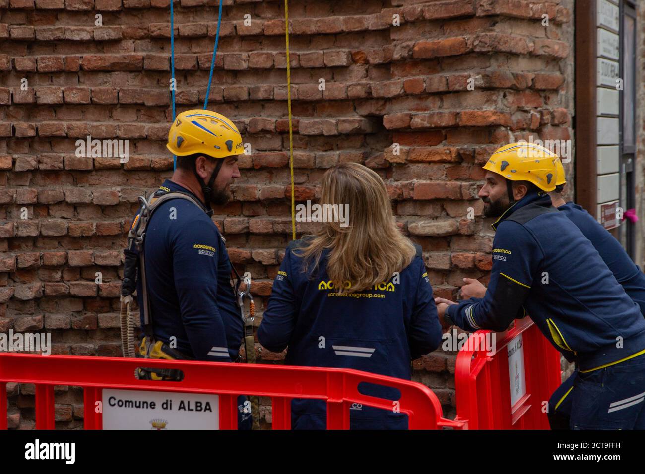 Seilzugangstechniker der Firma Acrobatica arbeiten gemeinsam daran, die letzten Takelinien an der Wand der Santa Maria Maddal zu spannen und zu sichern Stockfoto