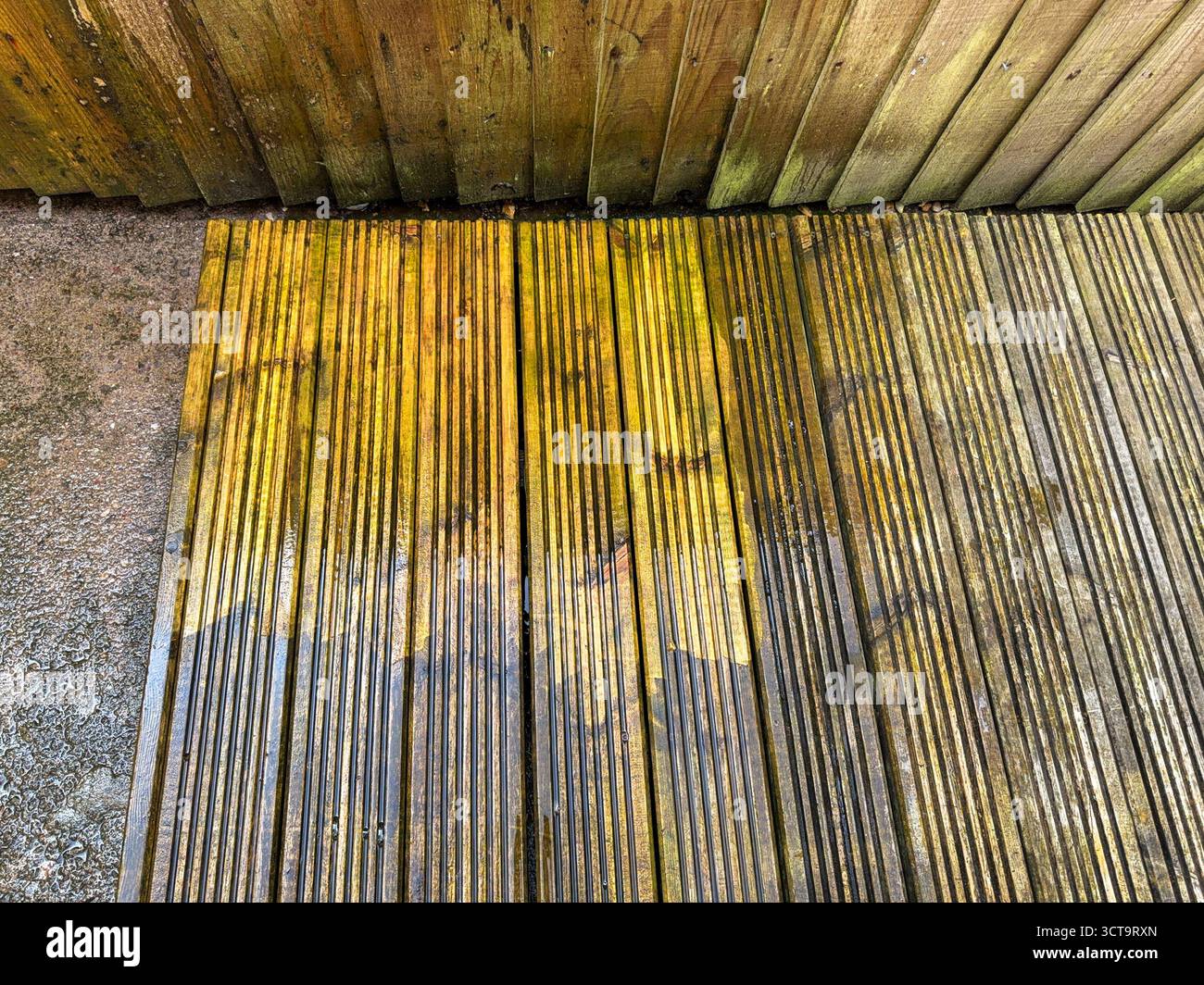 Vor und nach dem Anblick von Schmutz und Schmutz, der von Holzdielen mit einem Hochdruckreiniger gereinigt wird. DIY-Konzept. - Smartphone-aufgenommenes Stockfoto