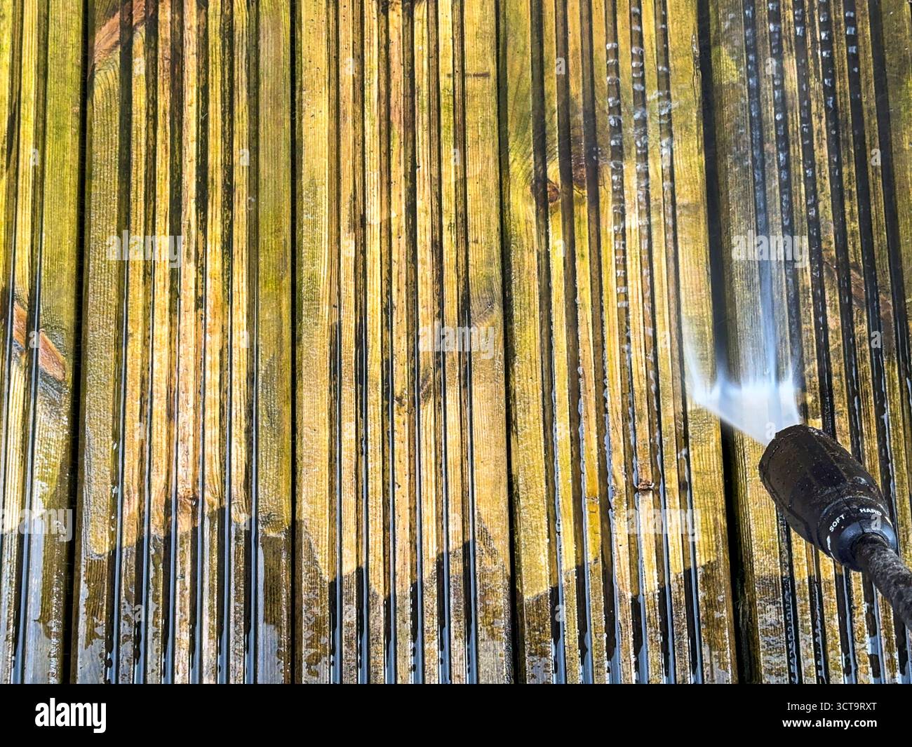 Vor und nach dem Anblick von Schmutz und Schmutz, der von Holzdielen mit einem Hochdruckreiniger gereinigt wird. DIY-Konzept. - Smartphone-aufgenommenes Stockfoto