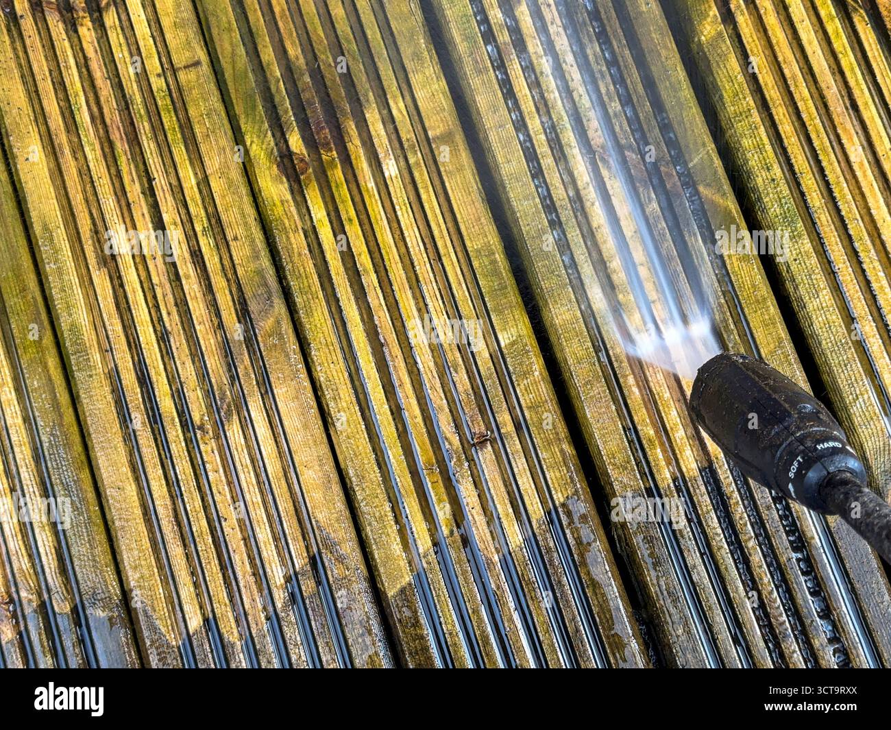 Vor und nach dem Anblick von Schmutz und Schmutz, der von Holzdielen mit einem Hochdruckreiniger gereinigt wird. DIY-Konzept. - Smartphone-aufgenommenes Stockfoto