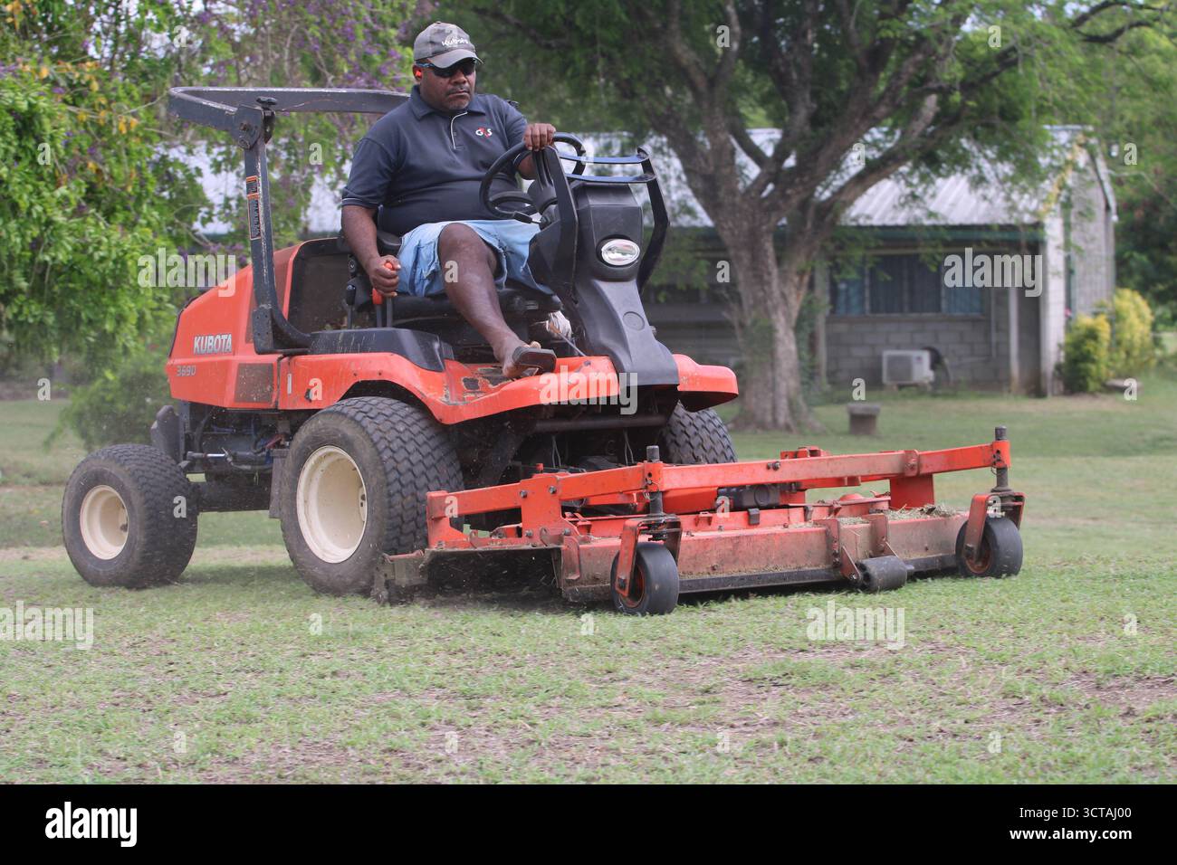 Bodenmesser mit einem Kubota Aufsitzmäher an der Pacific Adventist University, Port Moresby, Papua-Neuguinea Stockfoto