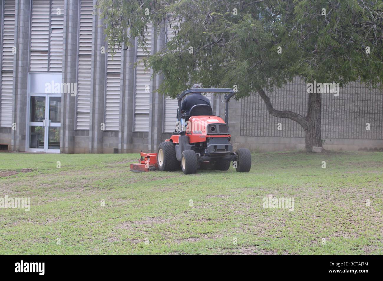 Bodenmesser mit einem Kubota Aufsitzmäher an der Pacific Adventist University, Port Moresby, Papua-Neuguinea Stockfoto