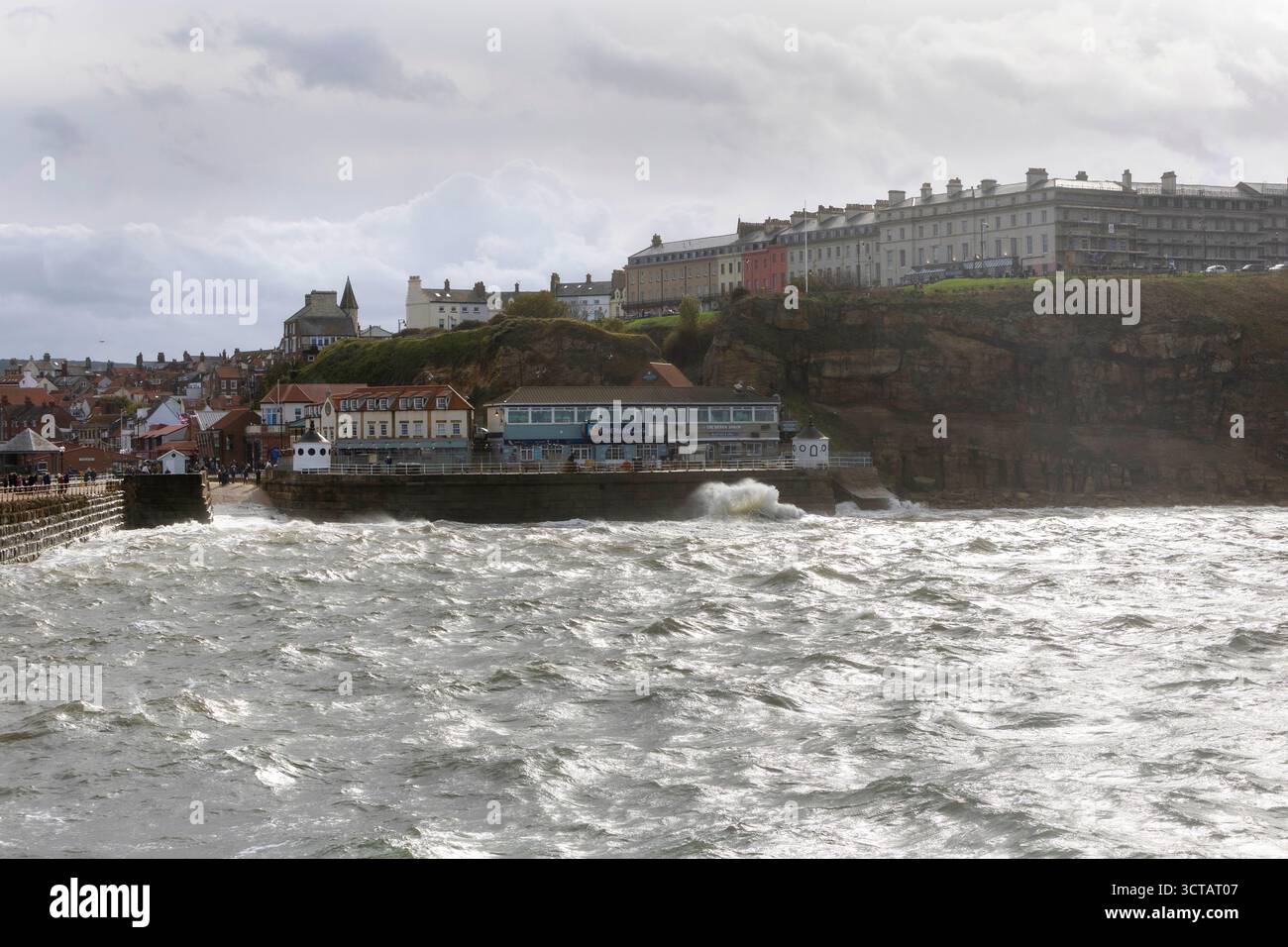 Sturm Amy bringt starke Westwinde und Wetter an die Küste von Yorkshire, die das Meer und die Wellen auf Whitby Küste und Strand entlang des Piers aufsaugen Stockfoto