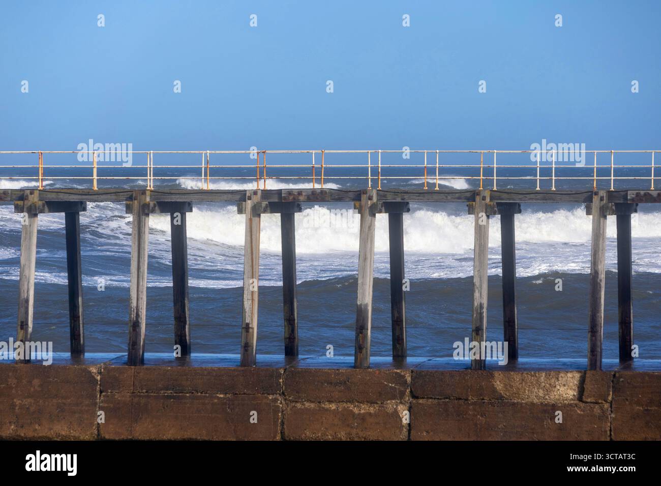 Sturm Amy bringt starke Westwinde und Wetter an die Küste von Yorkshire, die das Meer und die Wellen auf Whitby Küste und Strand entlang des Piers aufsaugen Stockfoto