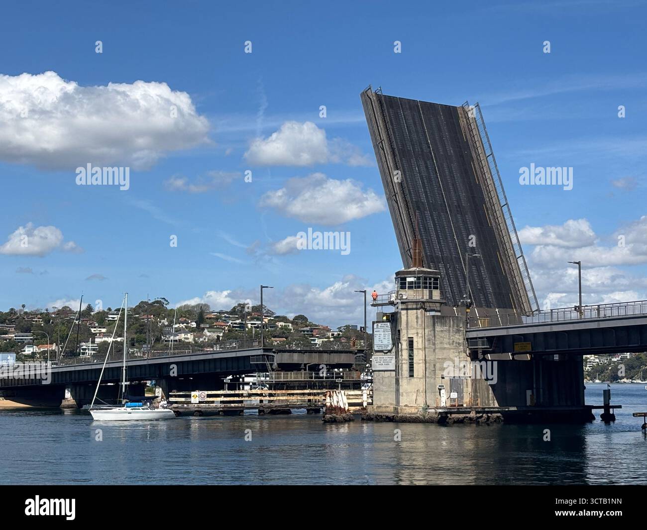 Yacht mit hohem Mast, die durch eine erhöhte Brücke an der Spit im Norden von Sydney, NSW, Australien führt. Keine PR - Smartphone-aufgenommenes Stockfoto