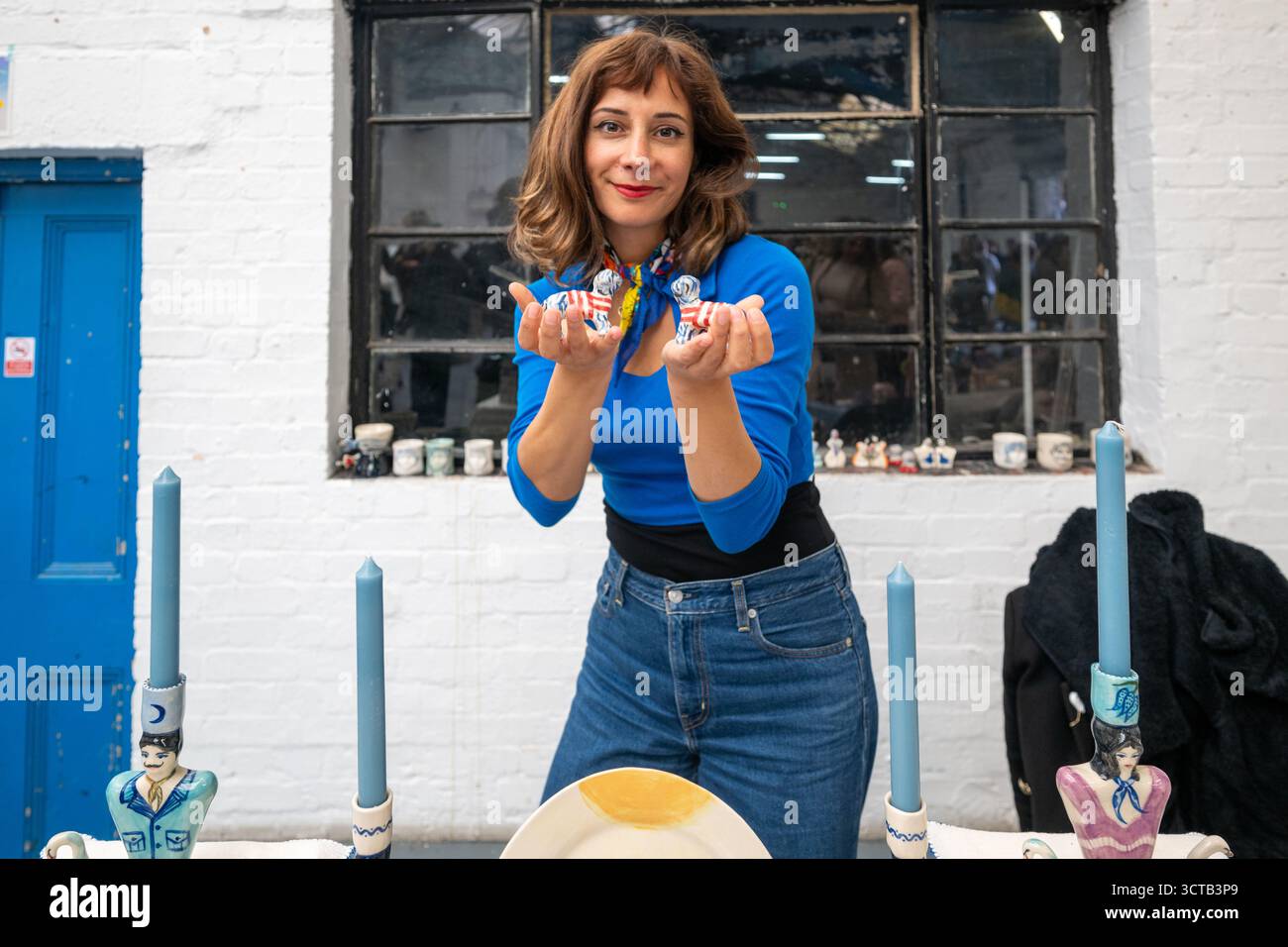 London, Großbritannien, 5. Oktober 2025, kamen große Menschenmassen auf den Autumn Independent Ceramic Market im Copeland Park, Peckham. Mit über 150 etablierten und aufstrebenden Keramikkünstlern aus ganz Großbritannien und Europa. Fotos der Künstlerin QBE QBE und ihrer Arbeit auf dem Markt., Andrew Lalchan Photography/Alamy Live News Stockfoto