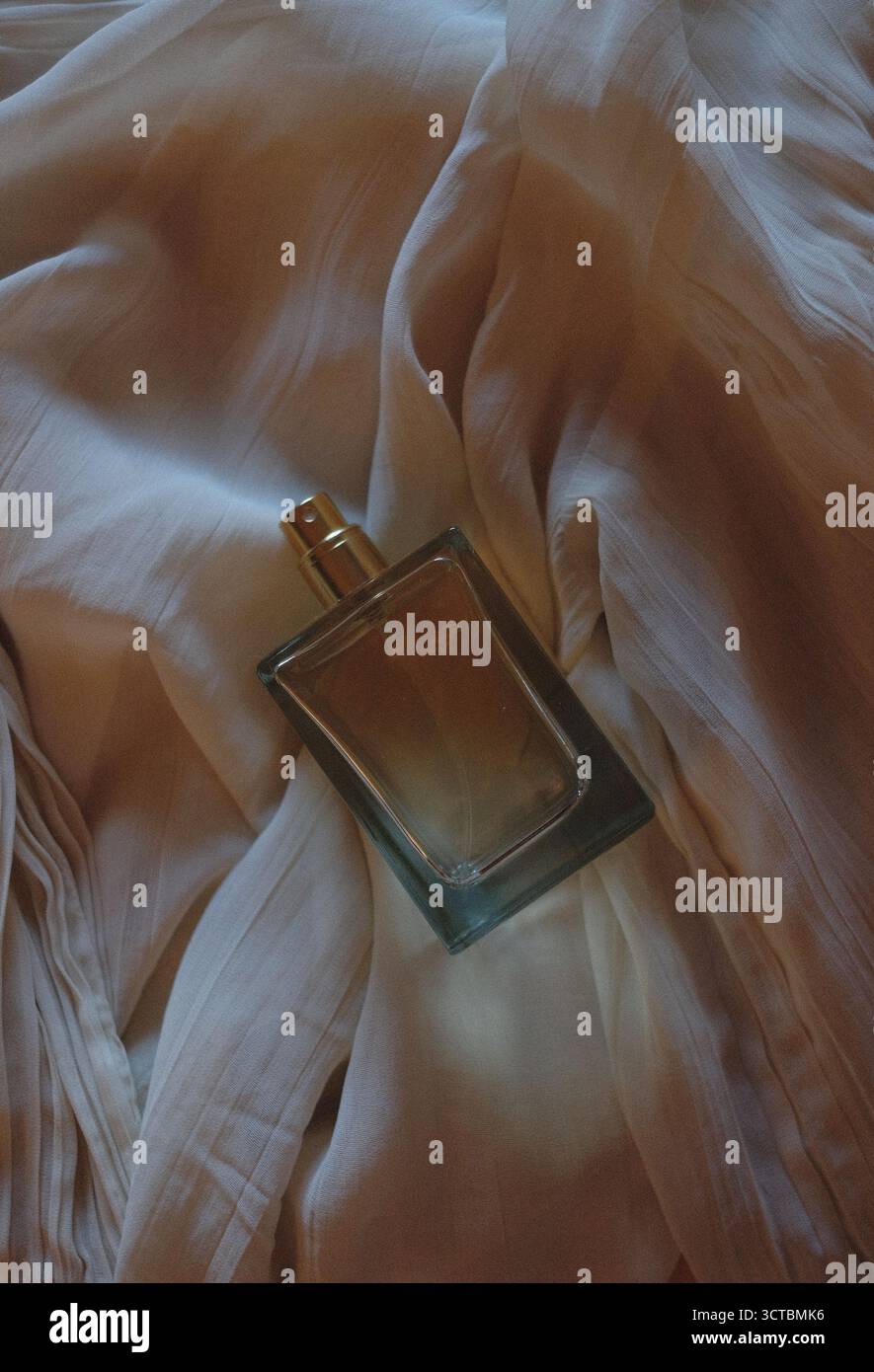 Rechteckige Parfümflasche auf weißem Seidenhintergrund Stockfoto