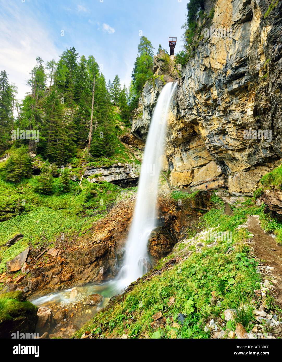Schönheit des Johannes Wasserfalls bei Obertauern, Österreich. Umgeben von üppigem Grün, stürzt der Wasserfall felsige Klippen hinunter und bietet atemberaubende Aussicht Stockfoto