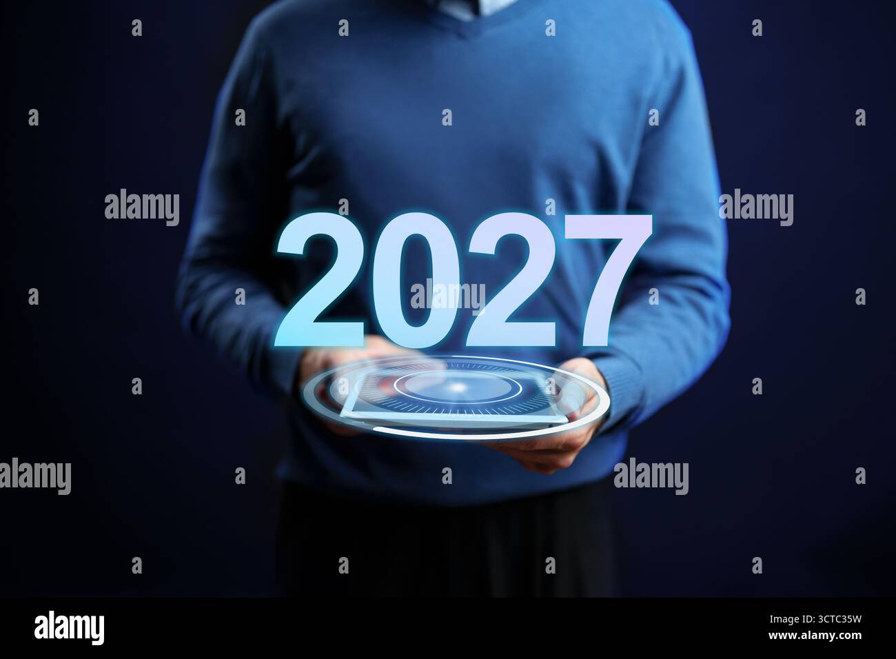 Zukunftsplanungssitzung zur Technikvorstellung 2027 durch eine Einzelperson in einem blauen Pullover Stockfoto