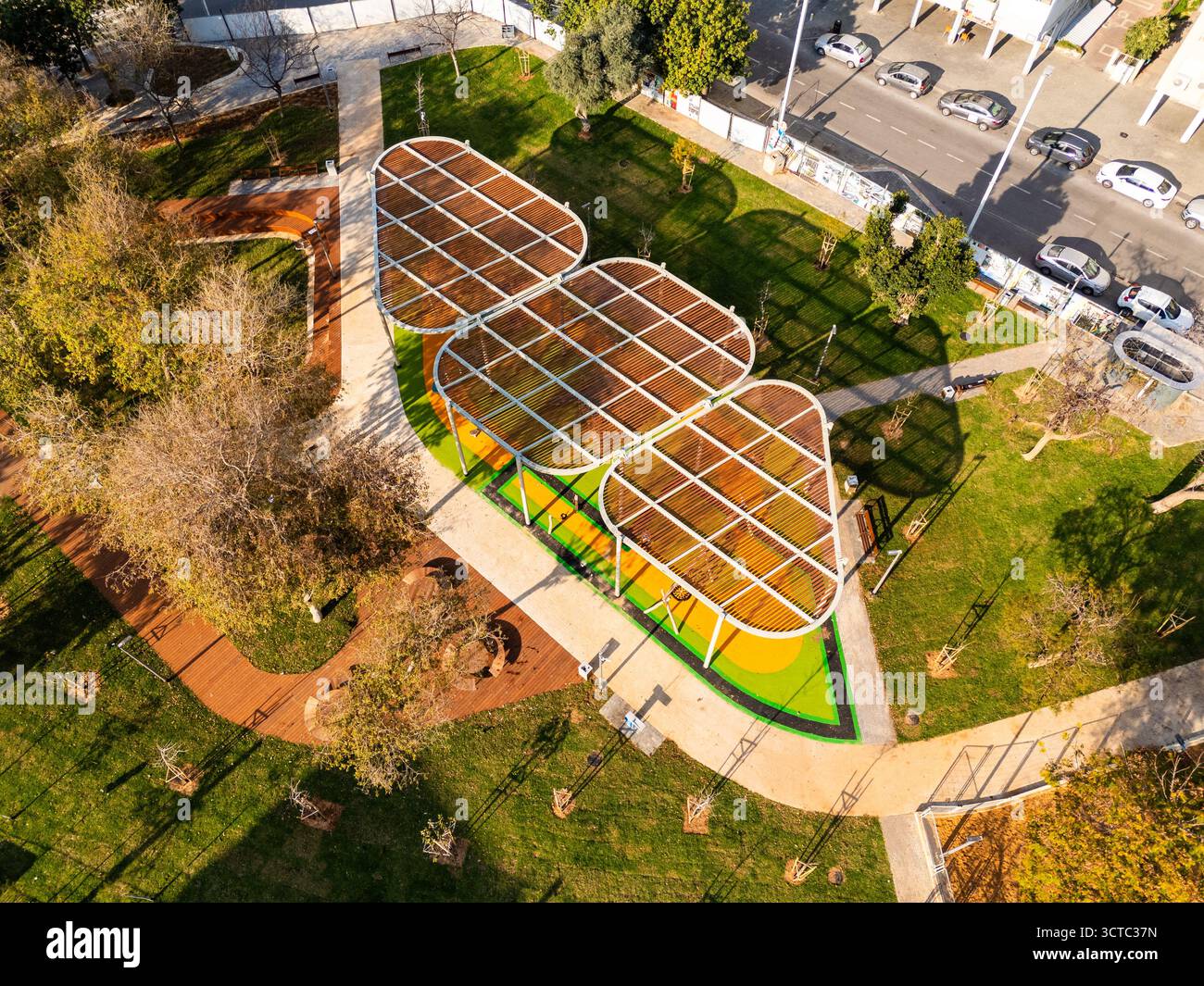 Blick aus der Vogelperspektive auf eine moderne architektonische Struktur mit orangefarbenem Dach inmitten der lebhaften grünen Landschaft eines öffentlichen Parks, bat Yam, Center District, ISR Stockfoto