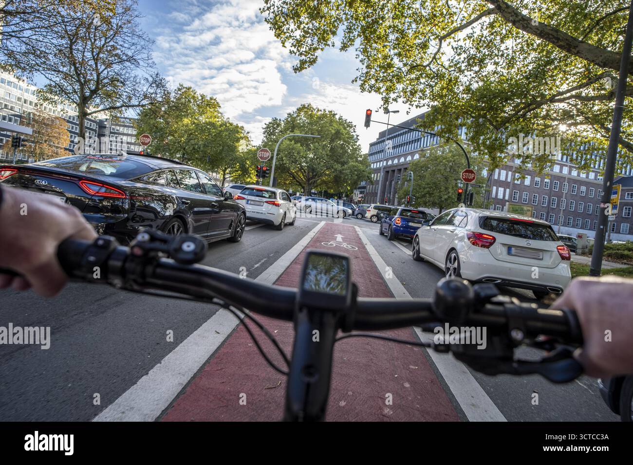 Radfahren auf einem rot markierten Radweg, der den Fahrern den Radweg bewusst macht, zwischen 2 Fahrspuren, Huyssenallee, im Stadtzentrum von Essen, Nord Stockfoto