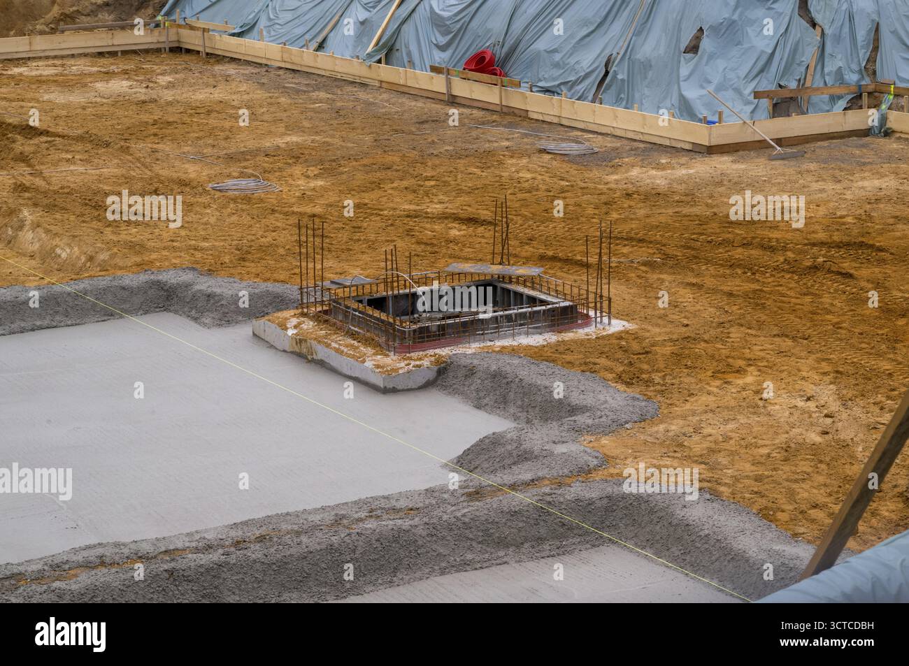 Neu gegossener Beton, der eine Fundamentplatte mit Bewehrungsrahmen auf einer Baustelle bildet Stockfoto