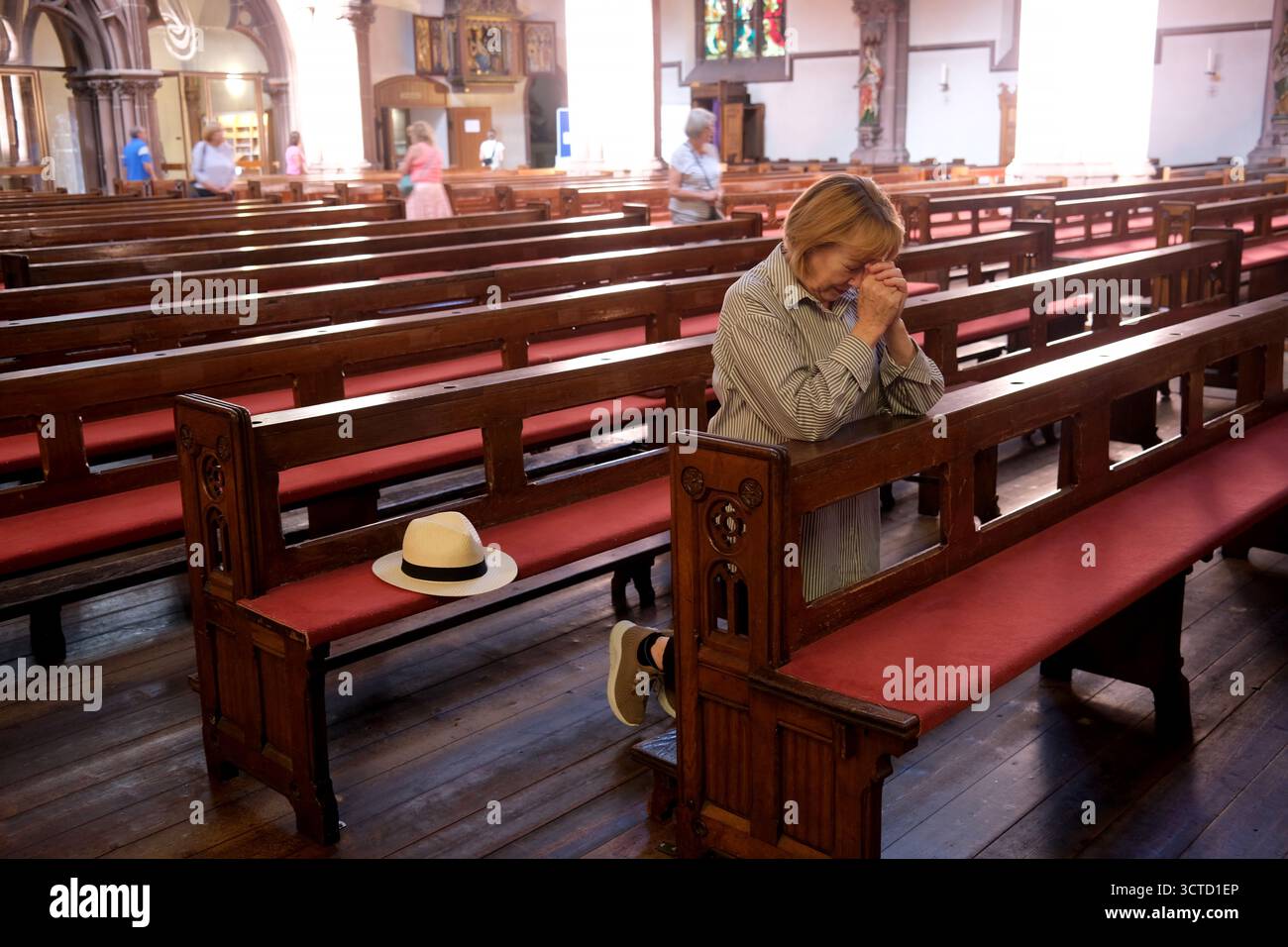 Christlich-katholische Frau betet in der katholischen Pfarrkirche St. Peter in Heppenheim Stockfoto