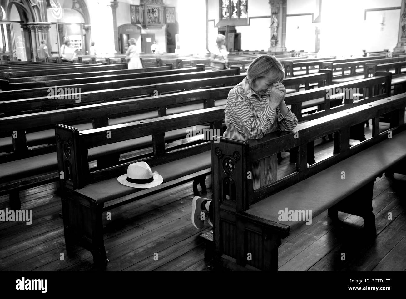 Christlich-katholische Frau betet in der katholischen Pfarrkirche St. Peter in Heppenheim Stockfoto