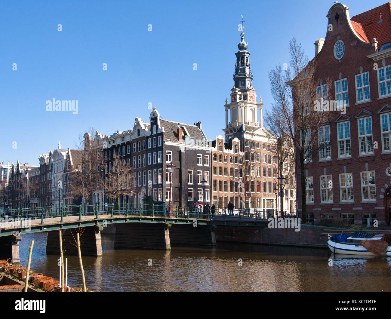 Klassischer Amsterdamer Kanal und Montelbaanstoren - berühmte Amsterdamer Kanalszene mit Brücke, historischen Giebelhäusern und dem unverwechselbaren Montelbaan Stockfoto