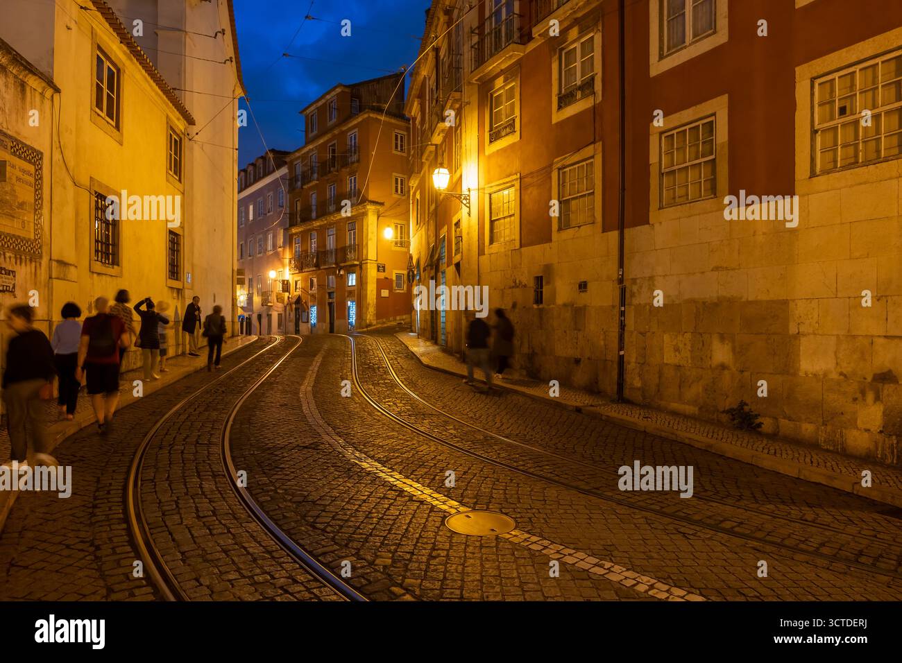 Alfama-Viertel in Lissabon bei Nacht in Portugal. Largo Santa Luzia Kopfsteinpflasterstraße mit Straßenbahnlinie der berühmten Straßenbahnlinie Nr. 28. Stockfoto