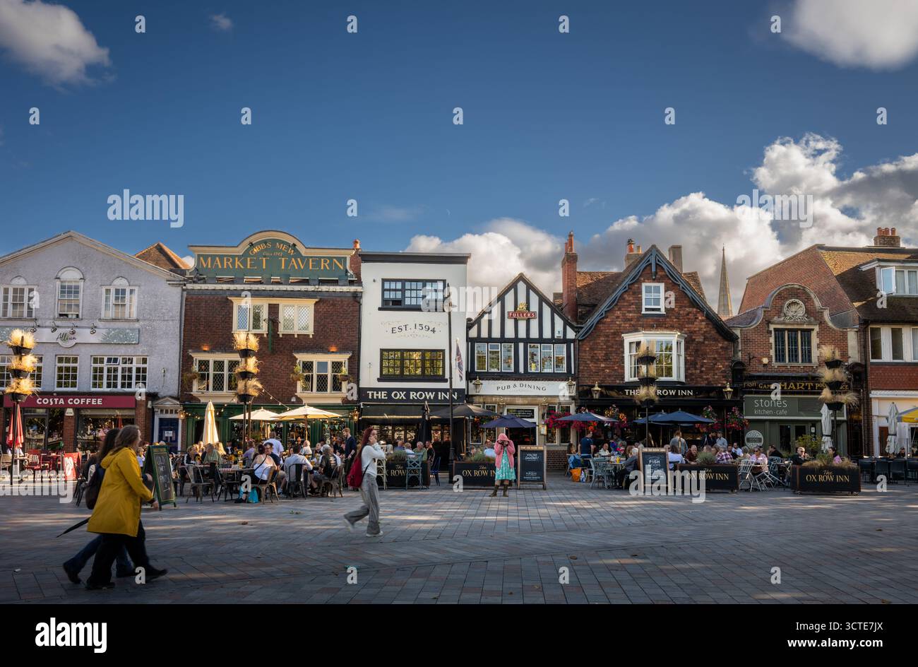 Salisbury, Wiltshire, Großbritannien: Der Marktplatz im Zentrum von Salisbury mit Ox Row. Die Leute sitzen vor den lokalen Pubs und genießen einen Drink in der Abendsonne Stockfoto