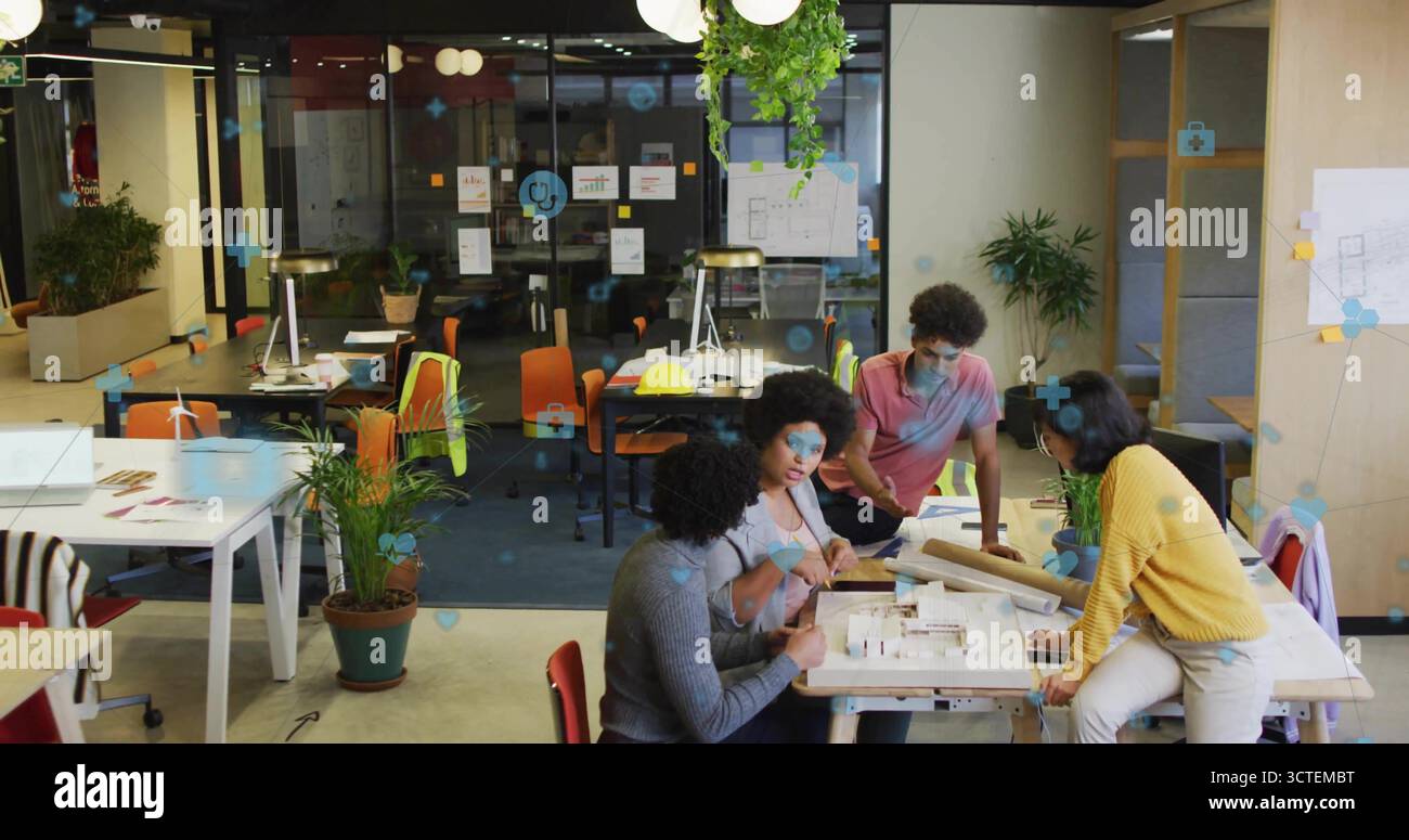 Zusammenarbeit mit vier Konstrukteuren, die das Modell im Großraumbüro mit Blaupausen und Stiften analysieren Stockfoto