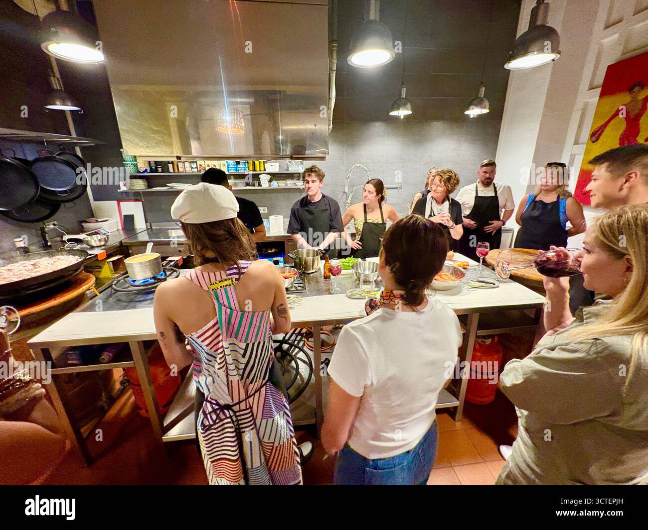 Barcelona Paella Kochkurs, Teilnehmer beobachten, wie der Cheflehrer Koch- und Vorbereitungsaufgaben für die Paella organisiert, Spanien, Europa - Smartphone-aufgenommenes Stockfoto