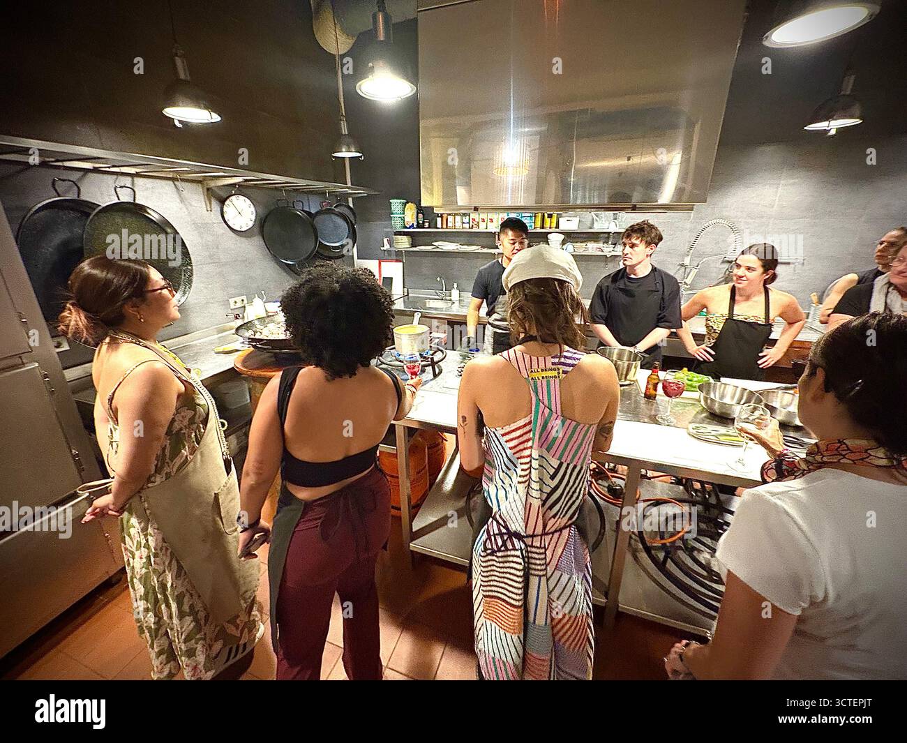 Barcelona Paella Kochkurs, Teilnehmer beobachten, wie der Cheflehrer Koch- und Vorbereitungsaufgaben für die Paella organisiert, Spanien, Europa - Smartphone-aufgenommenes Stockfoto