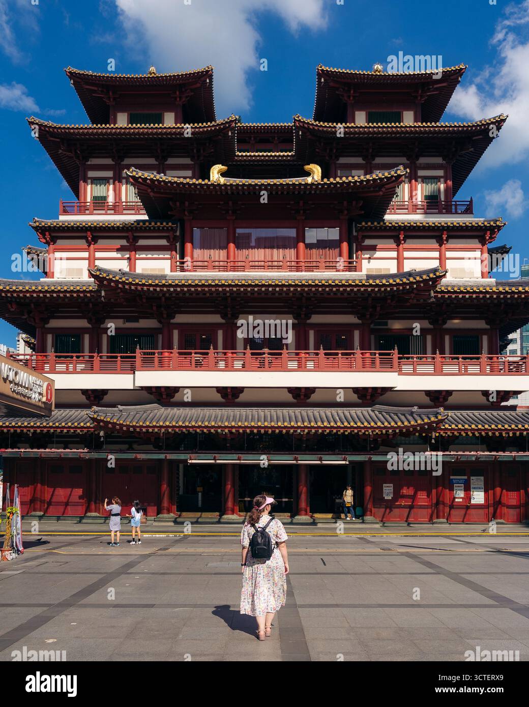 Singapur, Singapur - 09. April 2024: Blick auf den majestätischen Buddha-Zahn-Relikt-Tempel in Chinatown, wo die kräftigen roten Farbtöne der traditionellen Architektur im Kontrast zum klaren blauen Himmel stehen. Stockfoto