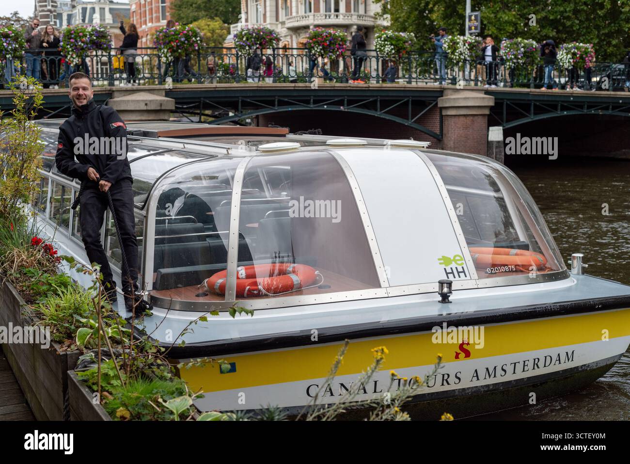Freundlicher Reiseleiter arbeitet für Canal Tours Amsterdam, beliebte touristische Besichtigungstouren durch die historische Altstadt, Amsterdam, Niederlande Stockfoto