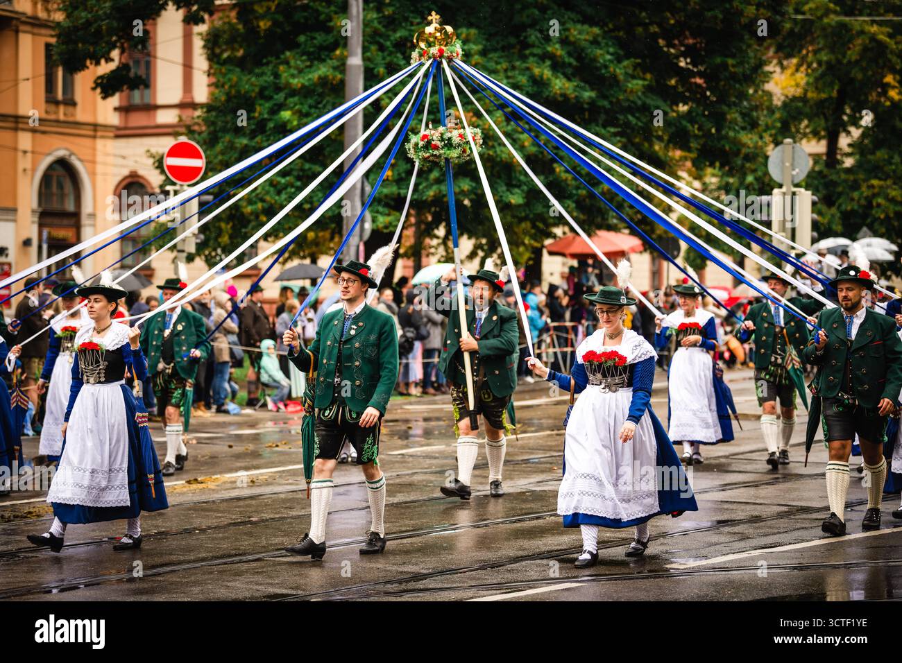 München, Deutschland - 18. September 2022: Blick auf eine traditionelle Oktoberfestparade mit lebhaften Kostümen, der Maypole und festlichem Geist gegen die Stadt Stockfoto München, Deutschland - 18. September 2022: Blick auf eine traditionelle Oktoberfestparade mit lebhaften Kostümen, der Maypole und festlichem Geist gegen die Stadt Stockfoto