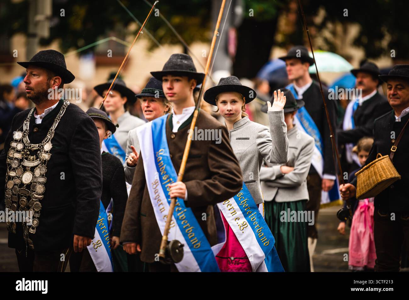 München, Deutschland - 18. September 2022: Blick auf eine pulsierende Oktoberfestparade mit Menschen in traditioneller bayerischer Kleidung, deren Gesichter die fes reflektieren Stockfoto München, Deutschland - 18. September 2022: Blick auf eine pulsierende Oktoberfestparade mit Menschen in traditioneller bayerischer Kleidung, deren Gesichter die fes reflektieren Stockfoto