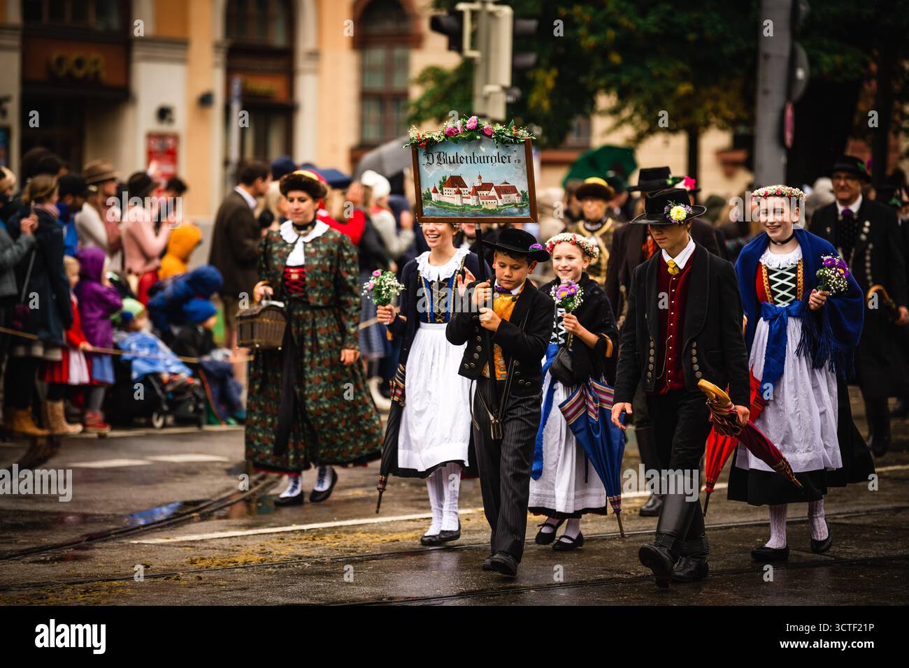 München, Deutschland - 18. September 2022: Blick auf eine pulsierende Oktoberfestparade mit Menschen in traditioneller bayerischer Kleidung, die mit c Stockfoto München, Deutschland - 18. September 2022: Blick auf eine pulsierende Oktoberfestparade mit Menschen in traditioneller bayerischer Kleidung, die mit c Stockfoto