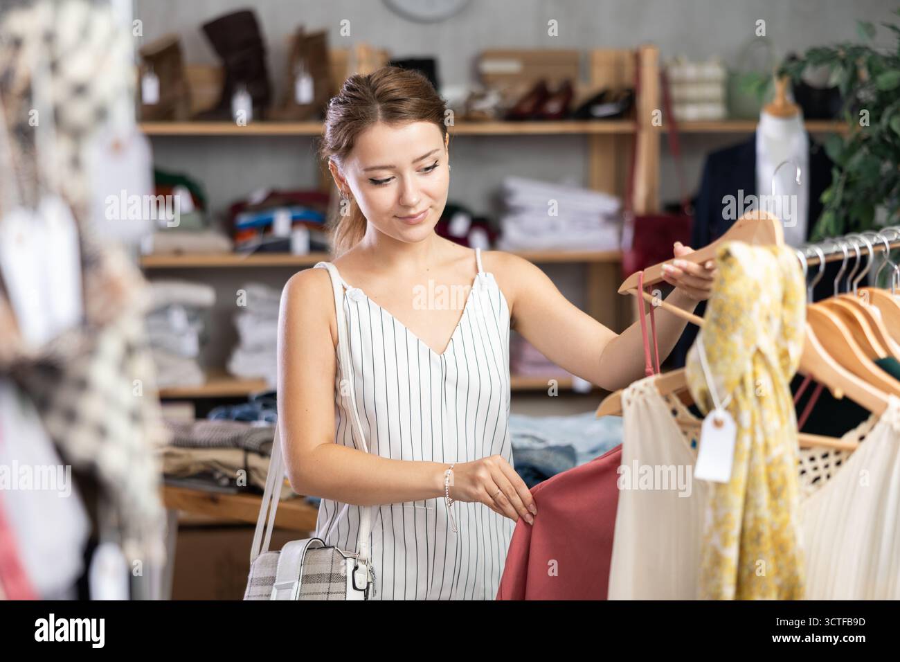 Die Frau wählt Kleidung aus der Sommerkollektion Stockfoto