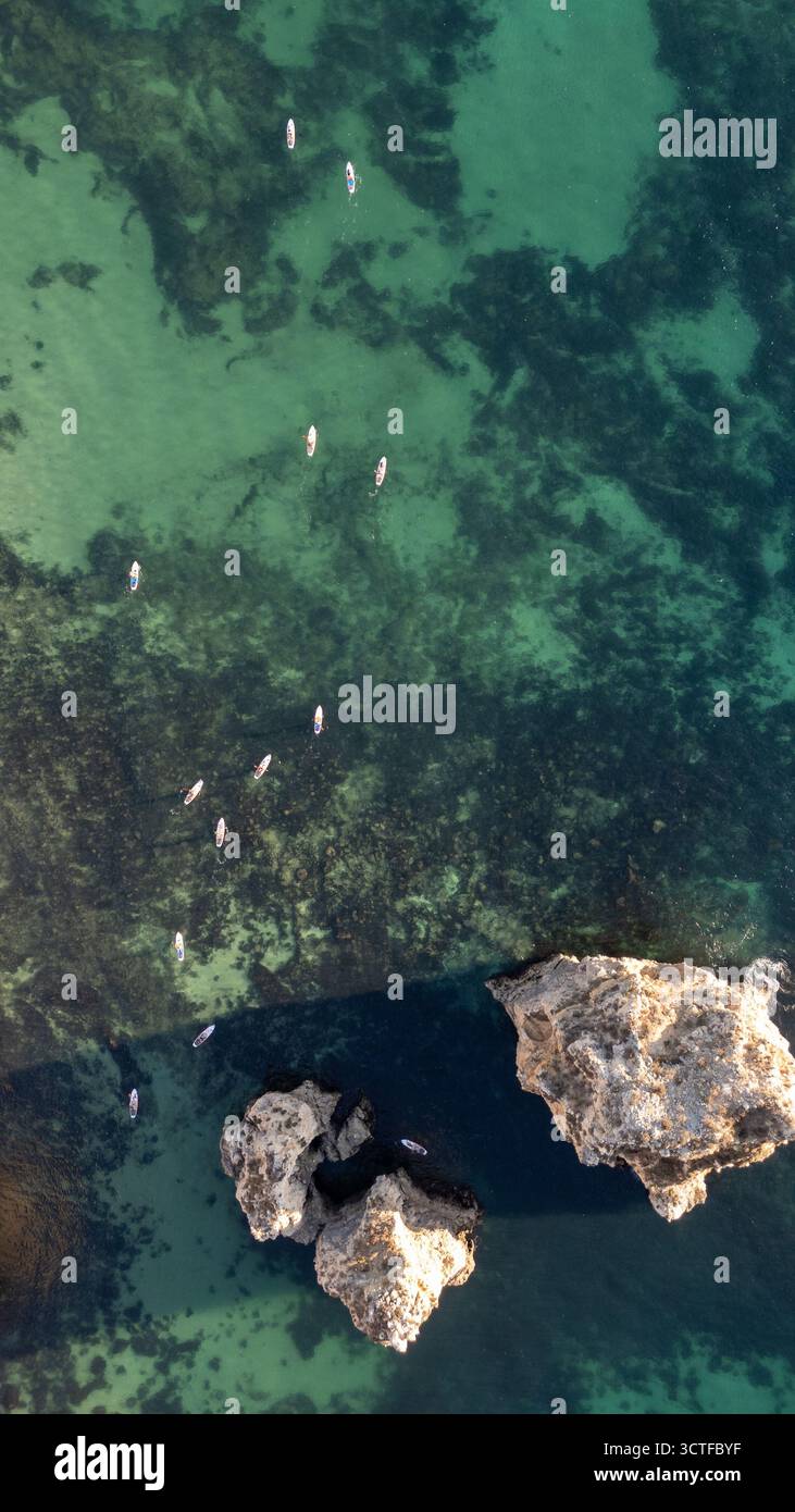 Portugal, Algarve. Klippen und Meer, von oben aus der Vogelperspektive auf Leute, die Paddelbrettsup machen Stockfoto