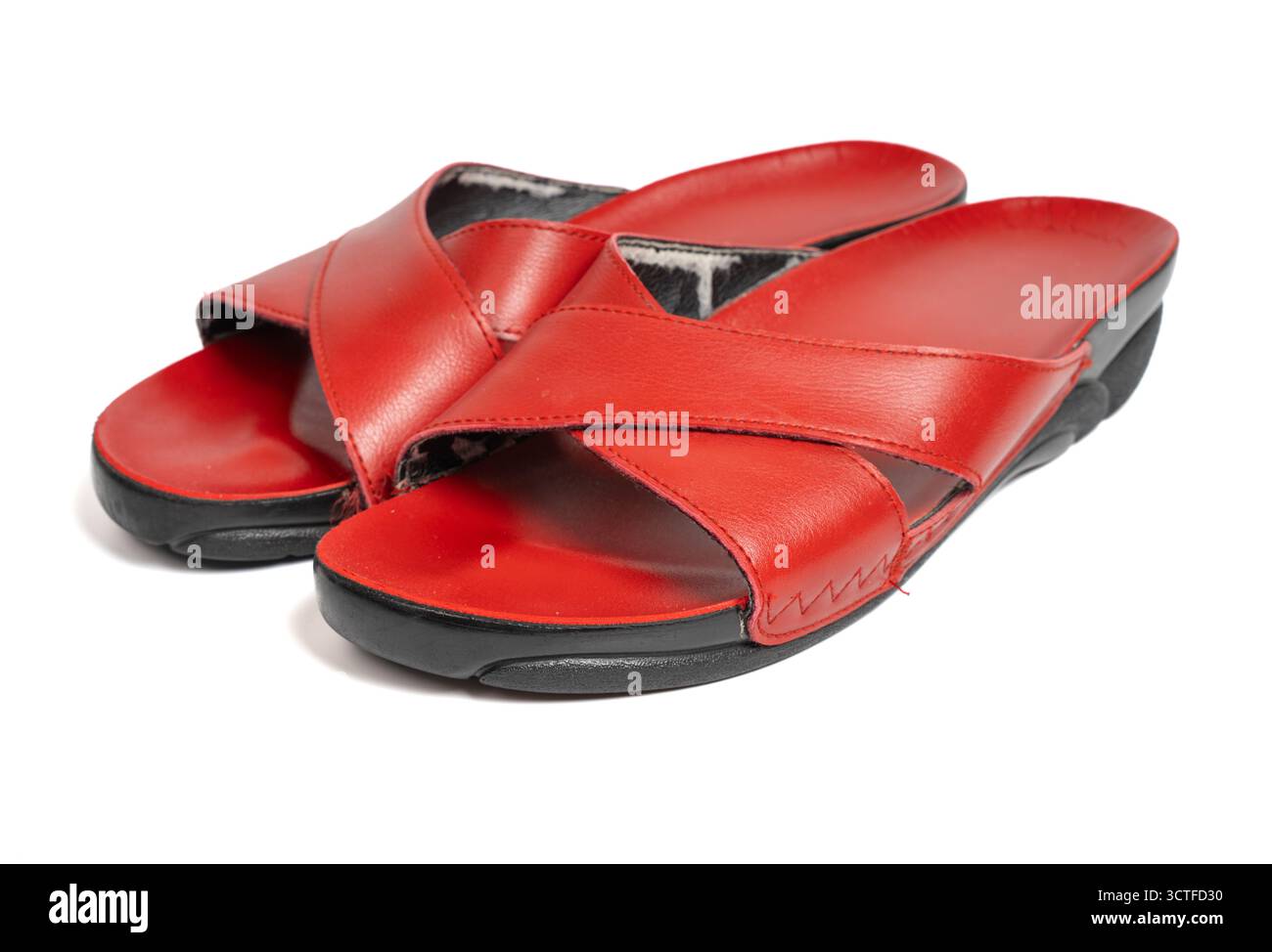 Paar rote Ledersandalen mit Kreuzriemen auf isoliertem weißem Hintergrund. Nahaufnahme von Sommerschuhen mit Crosscross-Design Stockfoto