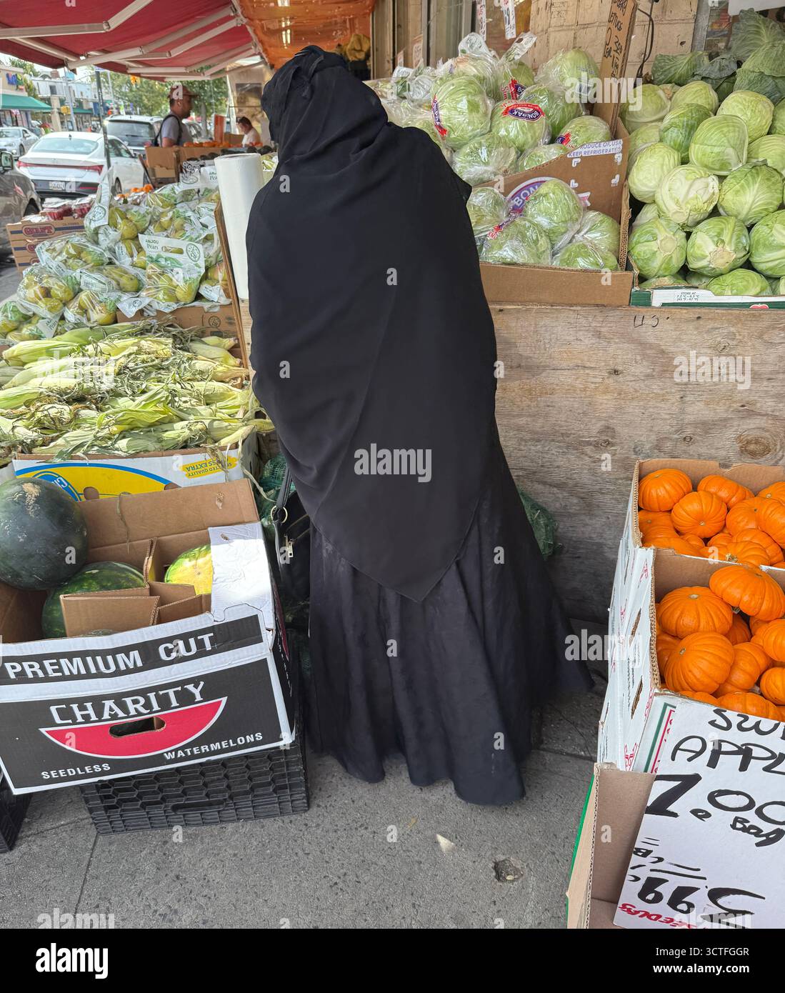 Weibliche muslimische Einwanderer kaufen auf einem Lebensmittelmarkt in der Church Avenue in Brooklyn, New York. Verdeckte Frauen, die in die USA kommen, finden sich von ihrem neuen Zuhause in den USA isoliert. Stockfoto