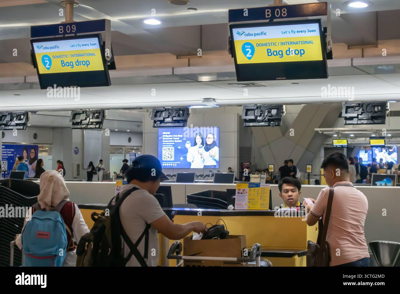 Reisende am Gepäckabgabe, Check-in, Cebu Pacific Air steht am Abflugterminal des Ninoy Aquino International Airport (NAIA) in Manila, Philippinen Stockfoto