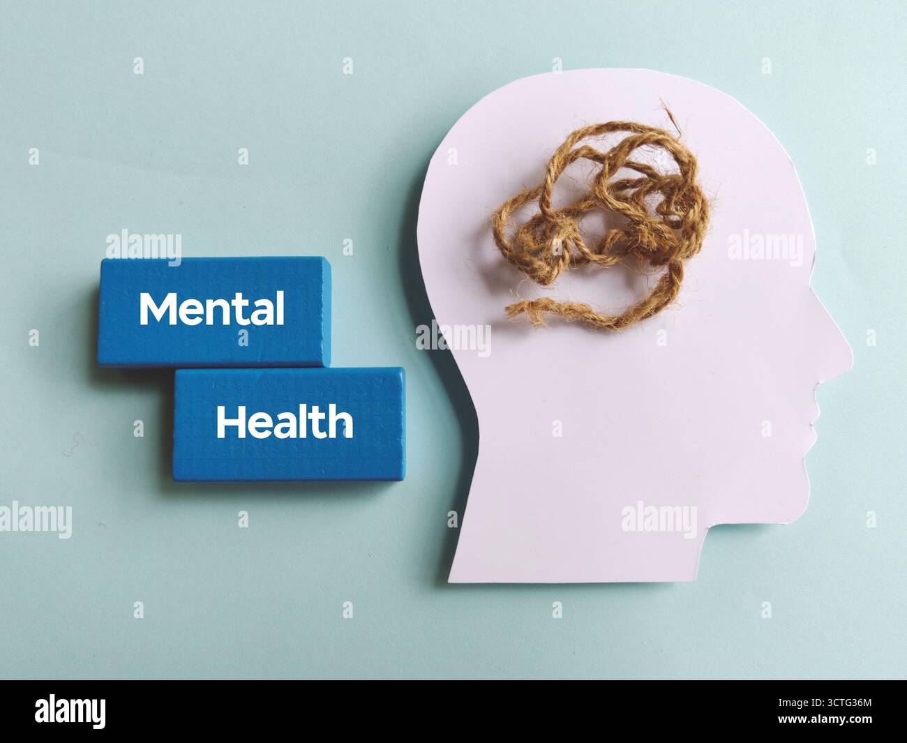 Text für psychische Gesundheit mit verworrenem String in der Kopfsilhouette, der Stress, Verwirrung und psychologischen Kampf symbolisiert Stockfoto