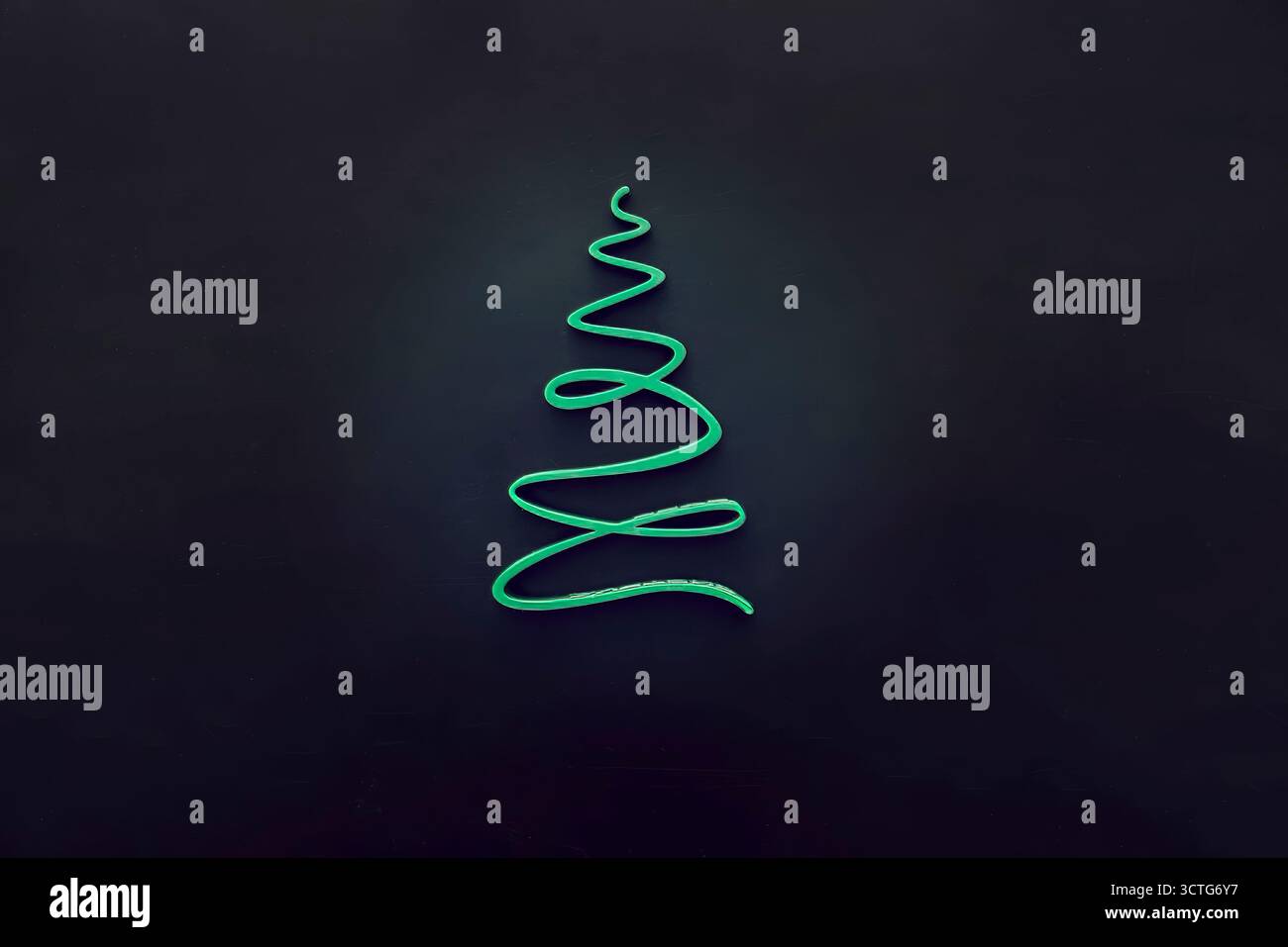 Ein einfacher, stilisierter Weihnachtsbaum in Grün vor dunklem Hintergrund. Das Design ist minimalistisch und modern, passend für Urlaubsthemen. Stockfoto