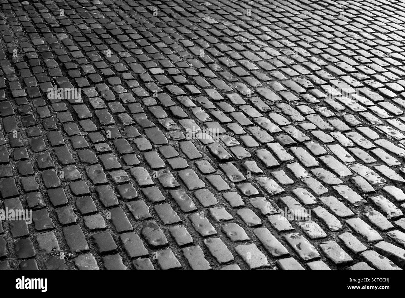 Alte Kopfsteinpflaster Straßenoberfläche in Schwarz-weiß Stockfoto