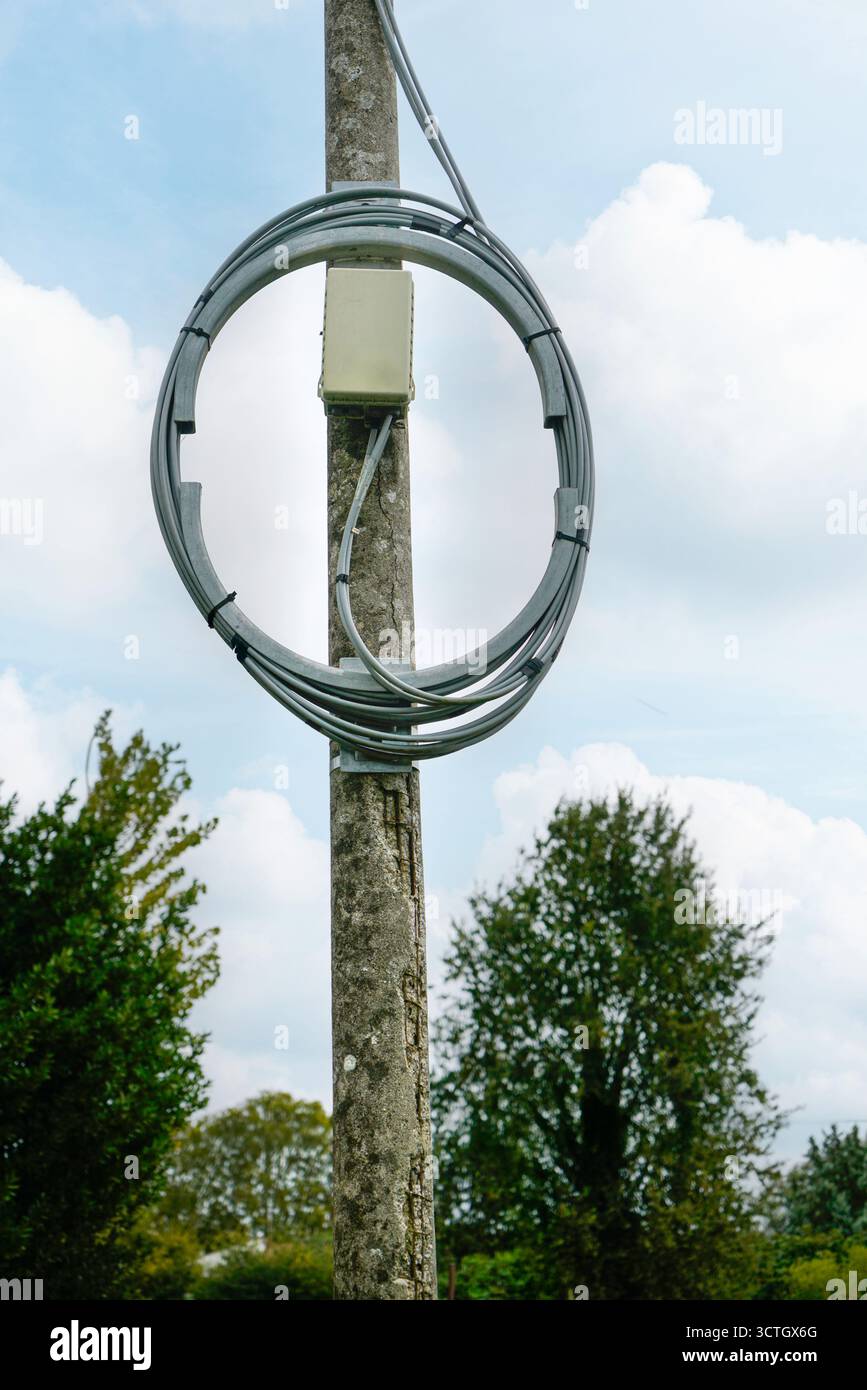 Ein elektrisches Kabel, das um einen Straßenlaternenpfosten gewickelt ist Stockfoto