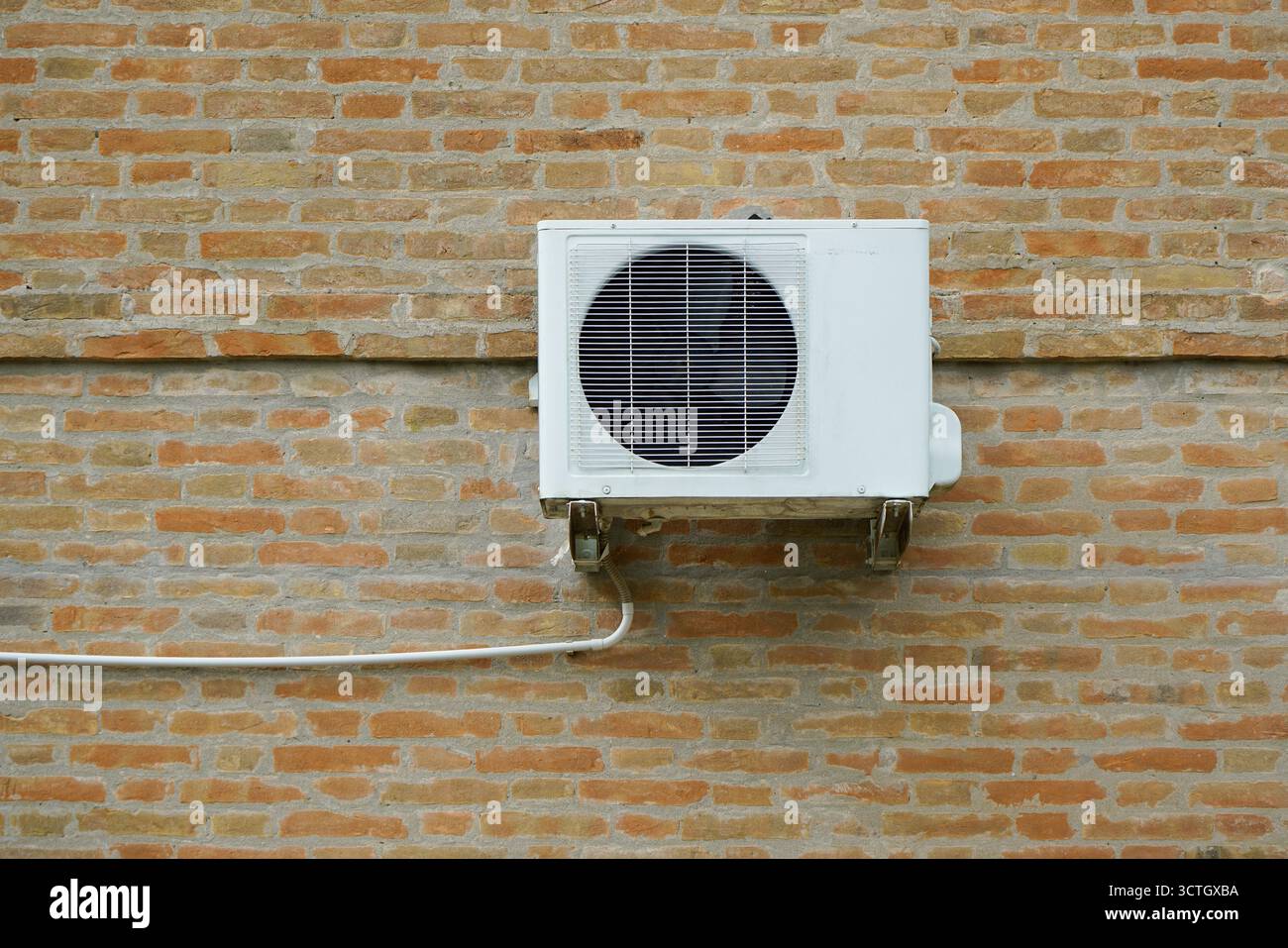 Die externe Einheit einer Klimaanlage, die an der Außenwand eines Hauses hängt Stockfoto