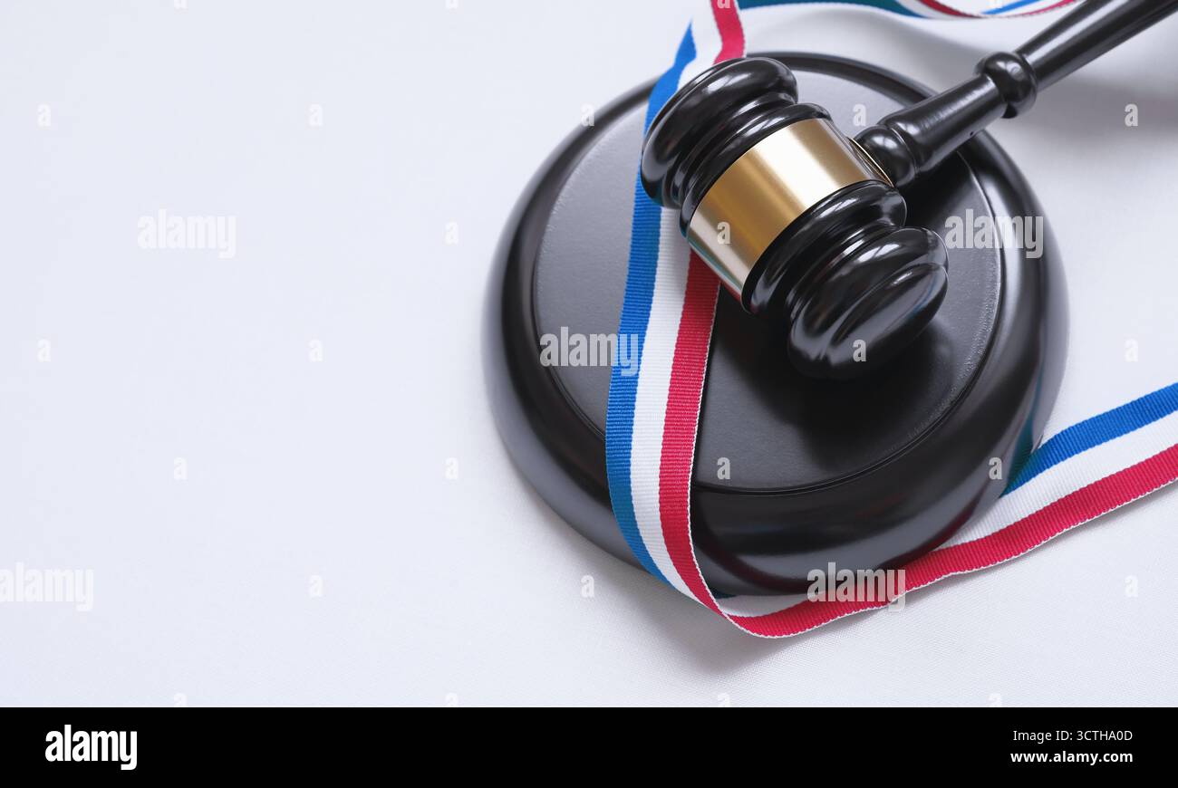 Französisches Recht, Rechtssystem, Gesetzgebung und Justizkonzept mit einer Draufsicht eines Richtergabels und einem dreifarbigen Band mit den Farben der französischen Flagge. Stockfoto