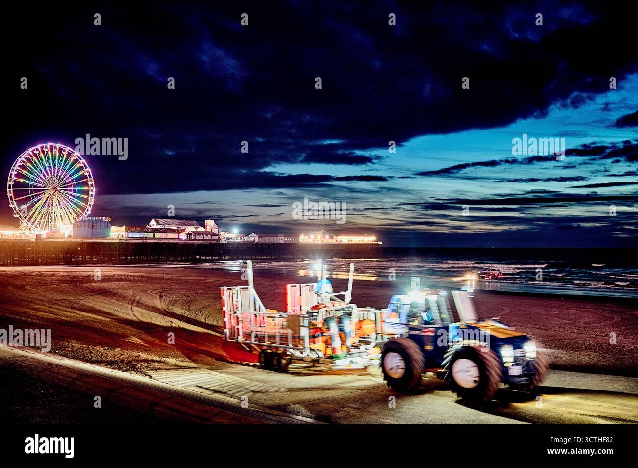 Fahrender Traktor und Anhänger verlassen den Strand nach RNLI-Nachtübung, Blackpool, UK Stockfoto
