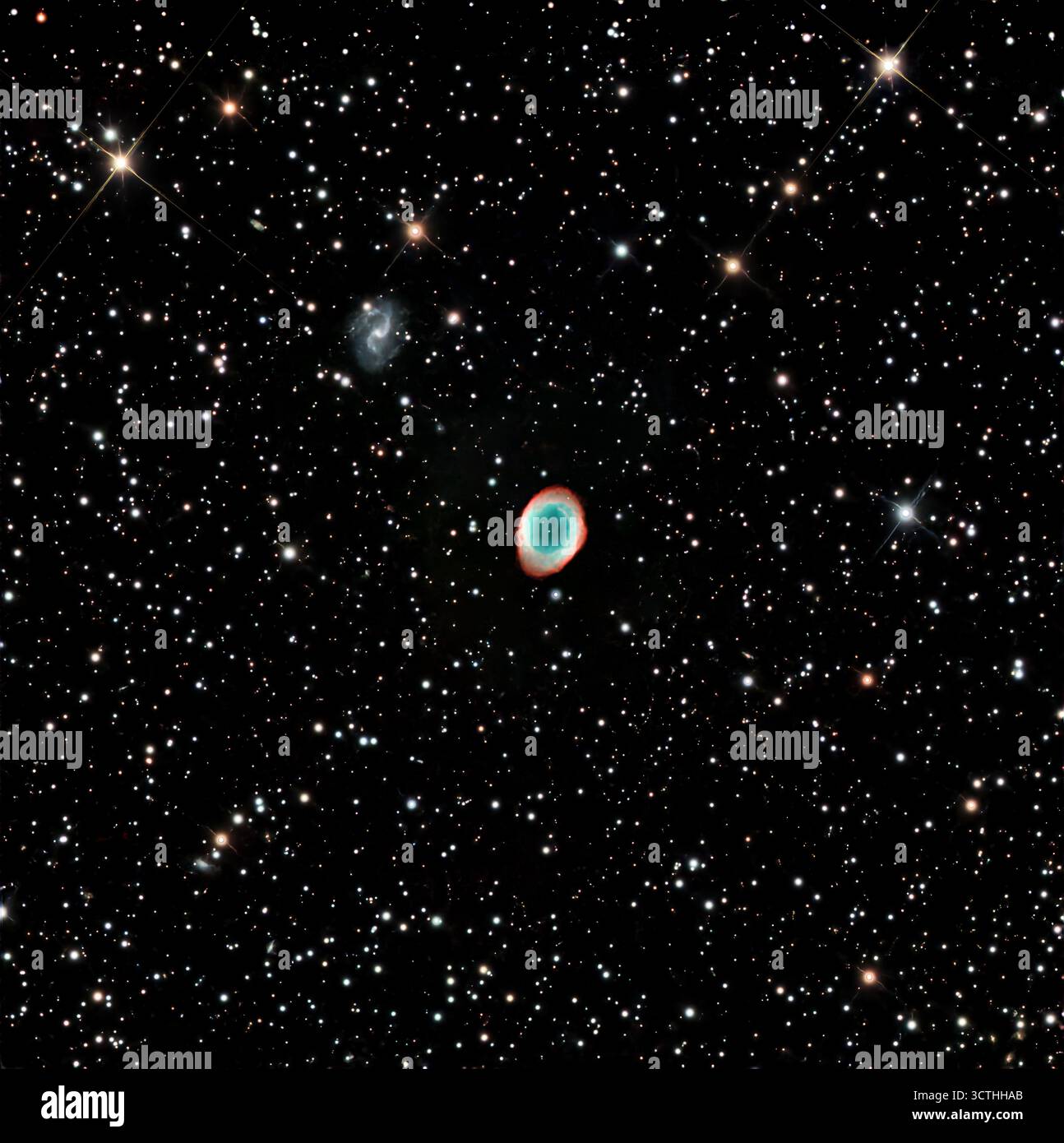 Der Ringnebel (Messier 57) und die Gitterspiralgalaxie IC1296 im Sternbild Lyra. M57 ist 2283 l entfernt, während IC1296 in einer Entfernung von App liegt. Stockfoto