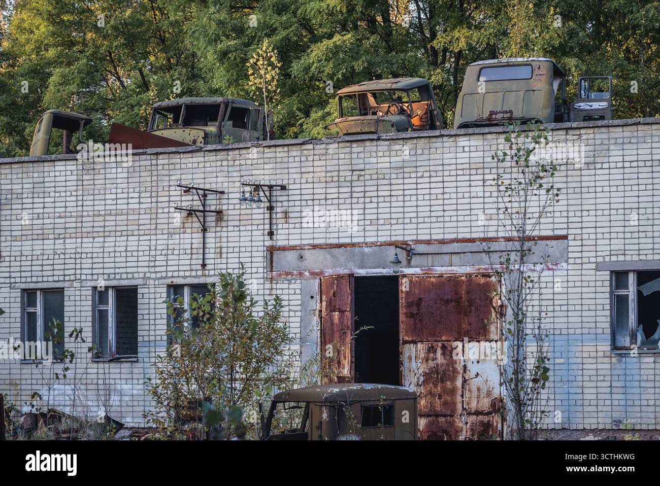 Alte Fahrzeuge auf dem Dach einer verlassenen Polizeistation in Pripyat Geisterstadt in Tschernobyl-Ausschlusszone, Ukraine Stockfoto Alte Fahrzeuge auf dem Dach einer verlassenen Polizeistation in Pripyat Geisterstadt in Tschernobyl-Ausschlusszone, Ukraine Stockfoto