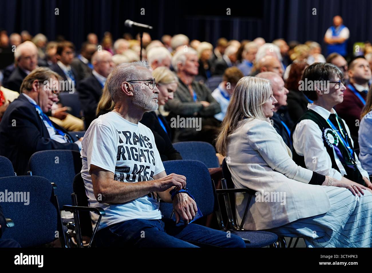 Ein Mitglied des Publikums, das ein T-Shirt mit der Aufschrift "Trans Rights are Human Rights" trägt, hört zu, wie Sharron Davies während der Konservativen Parteikonferenz im Manchester Central Convention Complex über die Teilnahme von Trans Women's Sport debattiert. Bilddatum: Dienstag, 7. Oktober 2025. Stockfoto