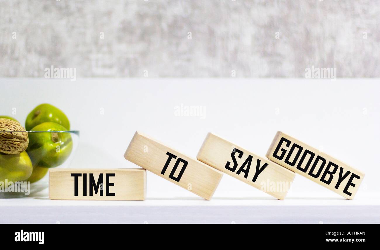 Zeit, sich zu verabschieden, ist ein Wort, das auf Holzblöcken geschrieben ist. Es ist Zeit, sich zu verabschieden – Text auf dem Tisch für Ihr Design, Ihr Konzept. Stockfoto